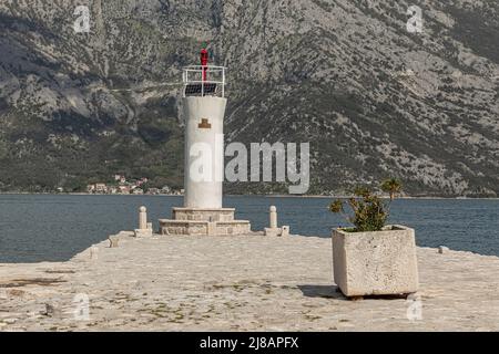 Kleines Leuchthaus auf einer Insel in Montenegro, das mit Solarstrom betrieben und weiß gestrichen wird Stockfoto