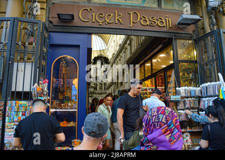 Am Samstag, den 14. Mai 2022, laufen die Menschen durch den Eingang des berühmten Cicek Pasaji (Blumenpassage) im Stadtteil Beyoglu in Istanbul, Türkei. Die Passage wurde 1876 eröffnet und ist eine überdachte Arkade mit Reihen historischer Cafés, Weinhäusern und Restaurants. Quelle: GocherImagery/MediaPunch Stockfoto