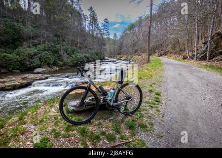 Ein gigantisches Kieselrad, das an einem bewölkten Tag in Virginia, USA, neben einem Fluss und Tunnel geparkt ist Stockfoto