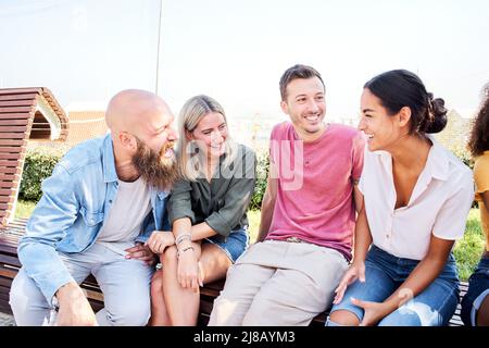 Gruppe von Menschen, die gemeinsam im Freien Spaß haben. Männer und Frauen lachen und genießen den Lebensstil. Stockfoto