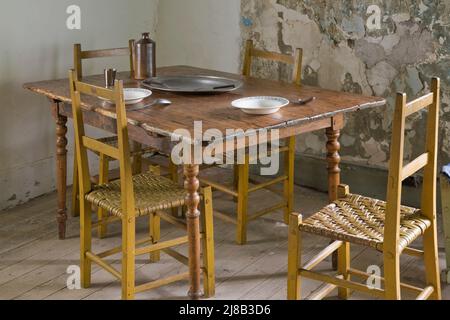 Antiker Esstisch und Stühle in der Küche im alten, um 1730 erregten französischen Stil Maison Drouin, Sainte-Famille, Ile d'Orleans, Quebec, Kanada. Stockfoto