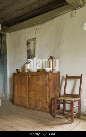 Antiker Schrank und Stuhl in der Küche im alten Gebäude um 1730, französisches Regime Maison Drouin, Sainte-Famille, Ile d'Orleans, Quebec, Kanada. Stockfoto