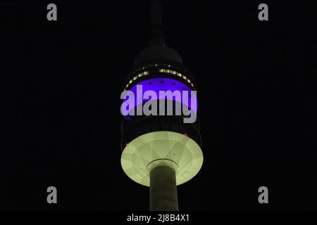 München, Deutschland. 14.. Mai 2022. Der Olympische Turm ist nachts in Blau und Gelb, den Farben der Nationalflagge der Ukraine, beleuchtet. Quelle: Felix Hörhager/dpa/Alamy Live News Stockfoto