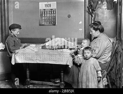 Woman and Young Boy Rolling Papers for Cigarettes in Dirty Tenement Apartment, New York City, New York, USA, Lewis Wickes Hine, Sammlung Des Nationalen Kinderarbeitsausschusses, März 1909 Stockfoto