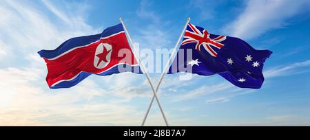Zwei gekreuzte Fahnen Nordkoreas und Australiens winken im Wind bei bewölktem Himmel. Konzept der Beziehung, des Dialogs, des Reisens zwischen zwei Ländern. 3D Abb. Stockfoto
