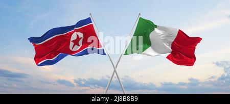 Zwei gekreuzte Fahnen Nordkoreas und Italiens winken im Wind bei bewölktem Himmel. Konzept der Beziehung, des Dialogs, des Reisens zwischen zwei Ländern. 3D illustrat Stockfoto