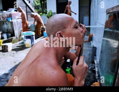 Batu City, Ost-Java, Indonesien. 14.. Mai 2022. Samaneras (Schüler von Mönchen) führen die Tradition der Haarrasur am Uposatha-Tag (buddhistischer Kalender) vor der Feier des Vesak-Tages in Vihara Dhammadipa Arama durch. Buddhisten feiern am Montag den Vesak-Tag 2566 BE/2022, einen glückverheißenden Tag, der an die Geburt, die Erleuchtung des Nirvana und den Tod von Gautama Buddha erinnert, dessen Lehren die buddhistische Religion bilden. (Bild: © Aman Rochman/ZUMA Press Wire Service) Stockfoto