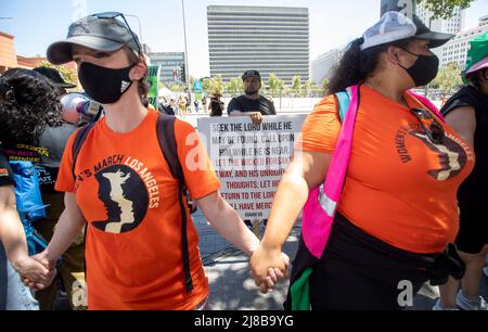 Los Angeles, CA, USA. 14.. Mai 2022. Die Freiwilligen von Women's march, Lindsey und Christina, verbinden die Waffen, während der evangelische Christ Mark Caldera ein Schild hinter sich hält, in der Nähe des Grand Parks nach einer Kundgebung vor dem Rathaus in der Innenstadt von Los Angeles. Heute gab es landesweit Proteste gegen Abtreibungsrechte, nachdem ein Entwurf einer Option ausging, der darauf hindeutete, dass der Oberste Gerichtshof Roe gegen Wade stürzen und damit das Recht der Frauen auf legale Abtreibungen rückgängig machen würde. (Bild: © Jill Connelly/ZUMA Press Wire) Stockfoto