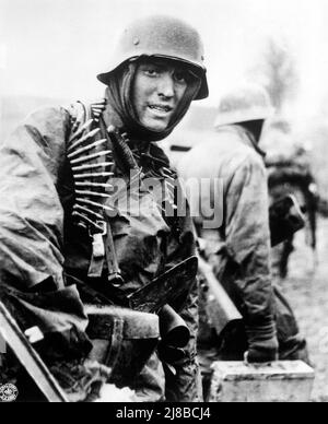 Deutscher Maschinengewehrschütze marschiert durch die Ardennen in der Bulge-Schlacht. Stockfoto