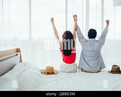 Ein paar Touristen, ein glücklicher Urlaub. Sommerurlaub. Porträt der Rückansicht von jungen asiatischen Mann und Frau, die Hände mit glücklich und fröhlich auf weiß werden Stockfoto