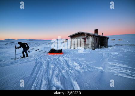 Skitouren in Lappland, Saarijärvi offene Wildnishütte im Hintergrund. Enontekiö, Lappland, Finnland Stockfoto