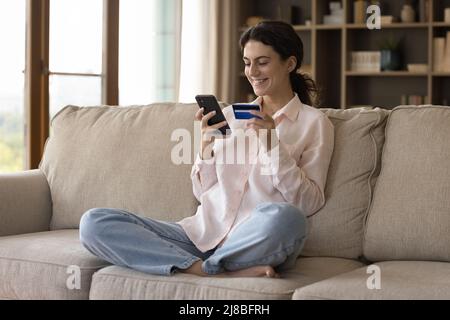 Frau mit Kreditkarte über das Smartphone online einkaufen Stockfoto