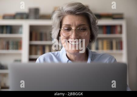 Fröhliche ältere Geschäftslehrerin Frau in stilvollen Gläsern Stockfoto