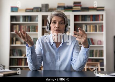 Ernst ältere grauhaarige College-Lehrer, die Online-Vortrag Stockfoto