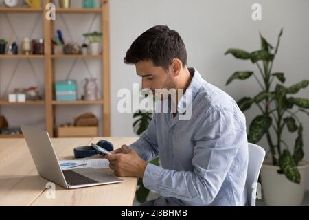 Seriöser, tausendjähriger freiberuflicher Mitarbeiter, der zu Hause arbeitet Stockfoto