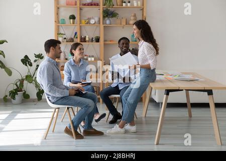 Mentorin und Praktikantin sitzen im Kreis zur Unternehmensschulung Stockfoto