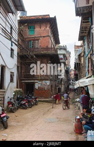 Kathmandu, Nepal - 27. Oktober 2021: Stadtbild der nepalesischen Hauptstadt. Eine staubige Straße in der Hauptstadt, schlechte Bedingungen in den Straßen Nepals. Citysca Stockfoto