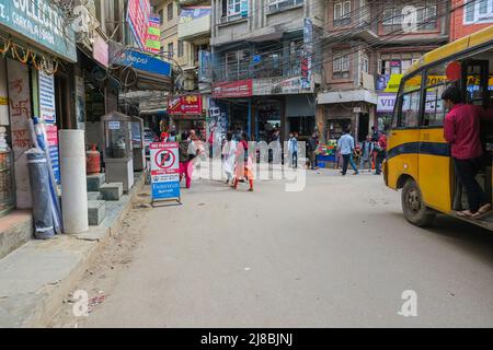 Kathmandu, Nepal - 11. September 2020: Die Innenstadt von Kathmandu ist nach wie vor von der Erdbebenkatastrophe geprägt. Gelber Bus ohne Türen, junger Mann auf der offenen Stockfoto