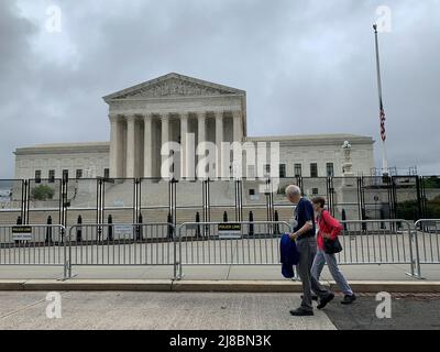 14. Mai 2022, Washington, District of Columbia, USA: Ein Paar geht an Zäunen vorbei, die den Obersten Gerichtshof der Vereinigten Staaten umzingen, der kurz nachdem ein Entwurf einer Stellungnahme, wonach Roe gegen Wade gestrichelt werden würde, an die Presse durchgesickert wurde, aufgestellt wurde. (Bild: © Sue Dorfman/ZUMA Press Wire) Stockfoto