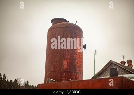 Rostiger Tank. Großer Metalltank auf der Straße. Alte Industrieanlage. Kesselanlagen. Stockfoto