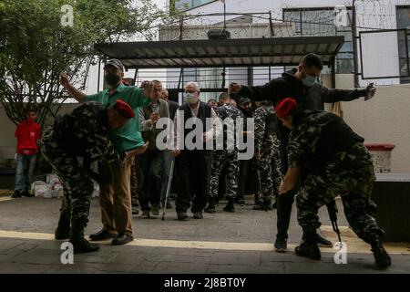 Beirut, Libanon. 15. Mai 2022, Libanon, Beirut: Libanesische Polizisten durchsuchen die Wähler, bevor sie während der libanesischen Parlamentswahlen 2022 in ein Wahllokal in Beirut eintreten. Foto: Marwan Naamani/dpa Kredit: dpa picture Alliance/Alamy Live News Stockfoto