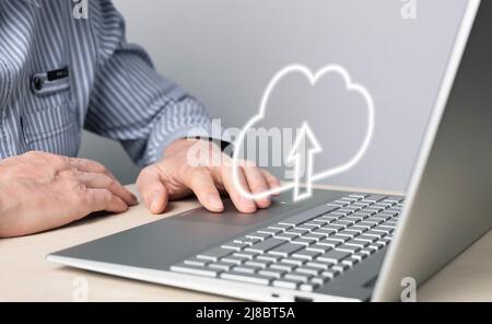 Cloud-Computing. Mann, der einen Laptop zum Hochladen, Speichern oder Teilen von Dateien online verwendet. Nahaufnahme mit männlicher Hand auf dem Touchpad des Computers. Hochwertige Fotos Stockfoto