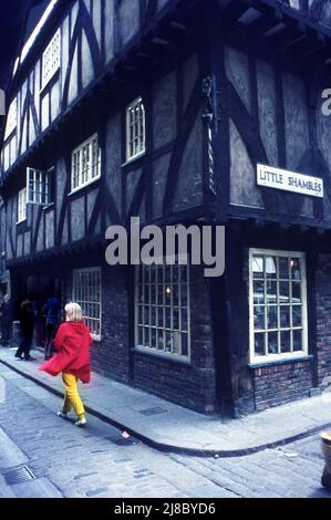 Farbenfroh gekleidete blonde Frau in den Shambles eine alte Straße in York, England Foto von Tony Henshaw Archive Stockfoto