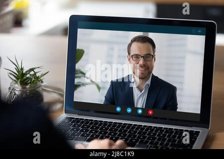 Laptop-Display mit Schnittstelle von Videoanruf an glückliche Geschäftsmann Stockfoto