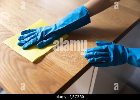 Hand des Reinigungsgerätes mit blauen Schutzhandschuhen aus Gummi, Waschtisch Stockfoto