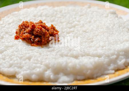 Milchreis mit würzigem Chili-Sambal auf einem Teller - traditionelle srilankische Küche Stockfoto