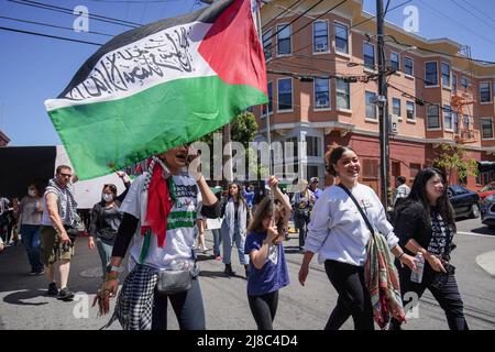 Während der Kundgebung halten die Demonstranten die Flagge Palästinas. Hunderte von Menschen nahmen an der Kundgebung „Rise Up for Palestine“ in San Francisco Teil, nachdem der Al Jazeera-Reporter Shireen Abu Aklei am 11. Mai 2022 getötet wurde, als sie über den Sturm auf das Flüchtlingslager Jenin im Westjordanland berichtete. Stockfoto