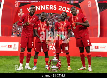 Liverpools (links-rechts) Divock Origi, Naby Keita, Sadio Mane und Ibrahima Konate posieren mit der Trophäe nach dem Finale des Emirates FA Cup im Wembley Stadium, London. Bilddatum: Samstag, 14. Mai 2022. Stockfoto