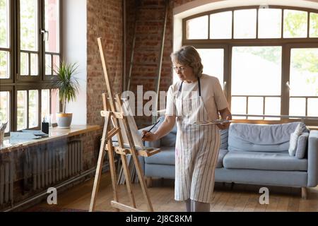 Junge afrikanische Künstlerin, die ein Bild auf Leinwand zeichnet Stockfoto