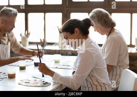 Multirassische Maler beschäftigten sich mit Malerei Kunst Klasse in der modernen Werkstatt Stockfoto