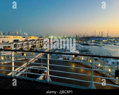 Blick auf die Stadt bei Nacht vom Deck eines im Hafen von Dubai stoppten Kreuzfahrtschiffs. Stockfoto