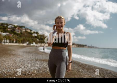 Gut aussehende junge Frau, die in der Nähe der Küste steht Stockfoto