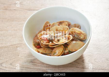 Gebratene Venusmuscheln mit gerösteter Chilischote auf der Schüssel umrühren Stockfoto