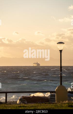 Himmel und Meer bei Sonnenuntergang und ein weit entfernes Schiff. Stockfoto