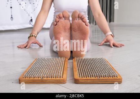 Ergebnis der Nagel stehend Praxis Frau Beine auf Sadhu Board Yoga Meditation Fußmassage Stockfoto