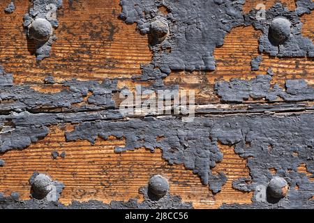 Durch Feuchtigkeit löste sich die Farbe von einer Holztür. Stockfoto