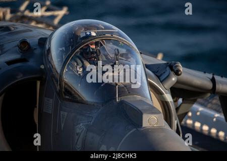U.S. Marine Corps AV-8B Harrier, der an das Schwarze Schaf der Marine Attack Squadron 214 befestigt ist, bereitet sich auf den Start vom Flugdeck des amphibischen Sturmschiffs USS Essex der Wasp-Klasse am 21. März 2021 auf den Pazifischen Ozean vor. Stockfoto
