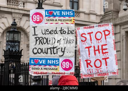 Whitehall, Westminster, London, Großbritannien. 15.. Mai 2022. Im Regen vor der Downing Street in Whitehall findet ein Protest gegen angebliche Lügen, Inkompetenz und Korruption des Premierministers Boris Johnson und der konservativen Regierung statt. Die Demonstranten sind wütend auf die Bilanz der Regierung in Bezug auf den Brexit, die Covid-Pandemie und die Lebenshaltungskrise und fordern Johnsons Rücktritt und höhere Standards von den Abgeordneten. Stoppen Sie das Rot-Plakat, und ich war stolz auf dieses Land Stockfoto