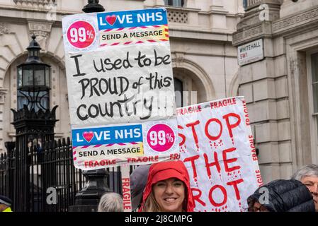 Whitehall, Westminster, London, Großbritannien. 15.. Mai 2022. Im Regen vor der Downing Street in Whitehall findet ein Protest gegen angebliche Lügen, Inkompetenz und Korruption des Premierministers Boris Johnson und der konservativen Regierung statt. Die Demonstranten sind wütend auf die Bilanz der Regierung in Bezug auf den Brexit, die Covid-Pandemie und die Lebenshaltungskrise und fordern Johnsons Rücktritt und höhere Standards von den Abgeordneten. Stoppen Sie das Rot-Plakat, und ich war stolz auf dieses Land Stockfoto