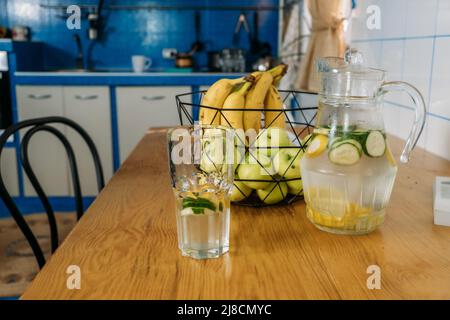 Frische Limonade im Glaskrug auf Holztisch. Sommergetränk eiskalte Limonade in Glas und Krug Stockfoto