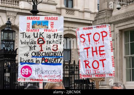 Whitehall, Westminster, London, Großbritannien. 15.. Mai 2022. Im Regen vor der Downing Street in Whitehall findet ein Protest gegen angebliche Lügen, Inkompetenz und Korruption des Premierministers Boris Johnson und der konservativen Regierung statt. Die Demonstranten sind wütend auf die Bilanz der Regierung in Bezug auf den Brexit, die Covid-Pandemie und die Lebenshaltungskrise und fordern Johnsons Rücktritt und höhere Standards von den Abgeordneten. Stoppt das Rot-Plakat und die Kinderarmut Stockfoto