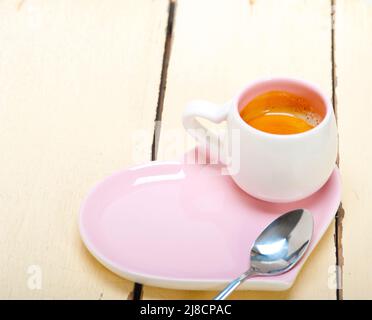 Espressokaffee serviert auf einem Teller rosa Herzform Stockfoto