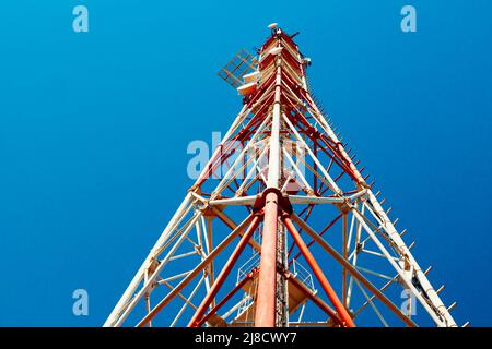 Der Kommunikationsturm steht gegen den Himmel mit einer Ansicht von unten nach oben. Nahaufnahme Stockfoto