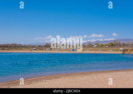 Der Issyk-Kul-See ist an einem sonnigen Frühlingstag der zweitgrößte Bergsee der Welt in Kirgisistan. Stockfoto