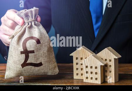 Britische Pfund Sterling Geldbeutel und Wohngebäude Zahlen. Steuern. Bank Angebot von Hypothekendarlehen. Mietgeschäft. Verkauf von Wohnungen. Kaufen. Investieren Stockfoto