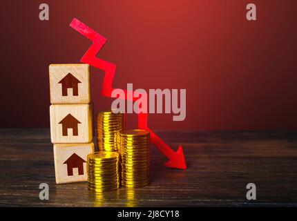 Immobilien und roter Pfeil nach unten. Niedrige Wohnungspreise. Reduzierte Hypothekenzinsen. Krise. Wartungskosten. Rezession. Bankrott und Zwangsvollstreckung. Erschwinglich Stockfoto